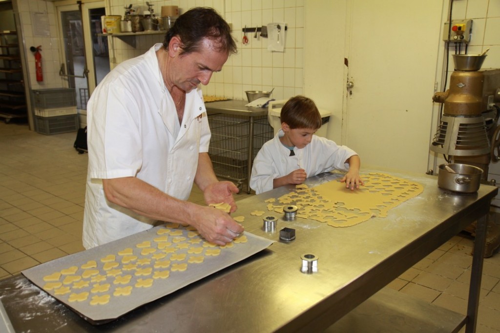 Bernard und TanguyTanguy sticht die Weihnachtsplätzchen aus und Bernard legt sie auf das Blech.