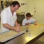 Bernard und TanguyTanguy sticht die Weihnachtsplätzchen aus und Bernard legt sie auf das Blech.