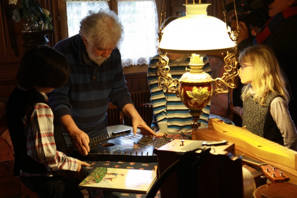 Kinder hören Renés Erklärungen zuRené erklärt, wie eine Zither funktioniert.