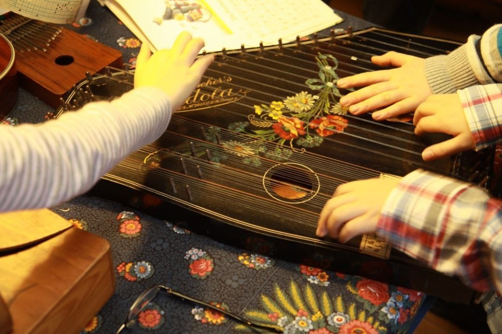 Die ZitherDie Kinder wollen alle gleichzeitig Zither spielen.